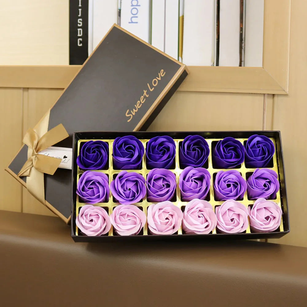 Box of purple and pink soap roses with 'Sweet Love' text on a wooden surface.