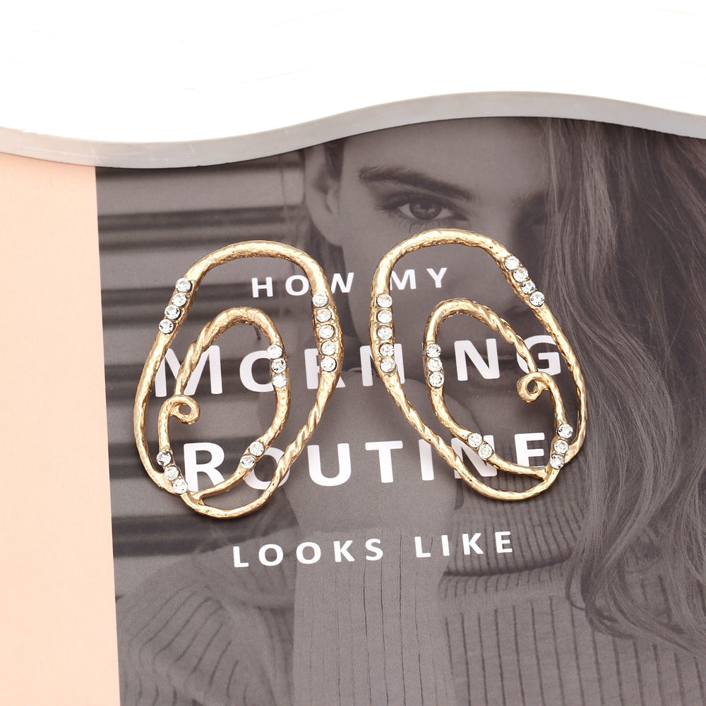 Gold hoop earrings with rhinestones on a magazine cover with text overlay.