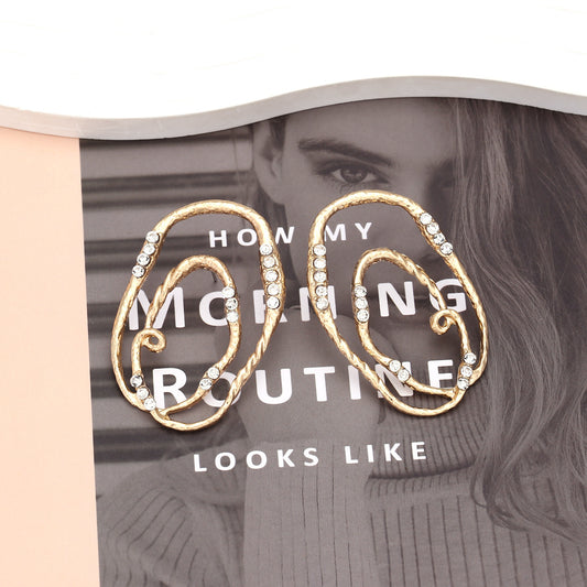 Gold hoop earrings with rhinestones on a magazine cover with text overlay.