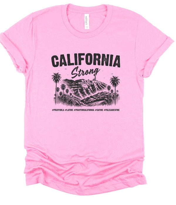 Pink unisex crew neck T-shirt featuring a black "California Strong" graphic with the Hollywood sign, palm trees, and mountain landscape, representing Los Angeles pride and resilience.