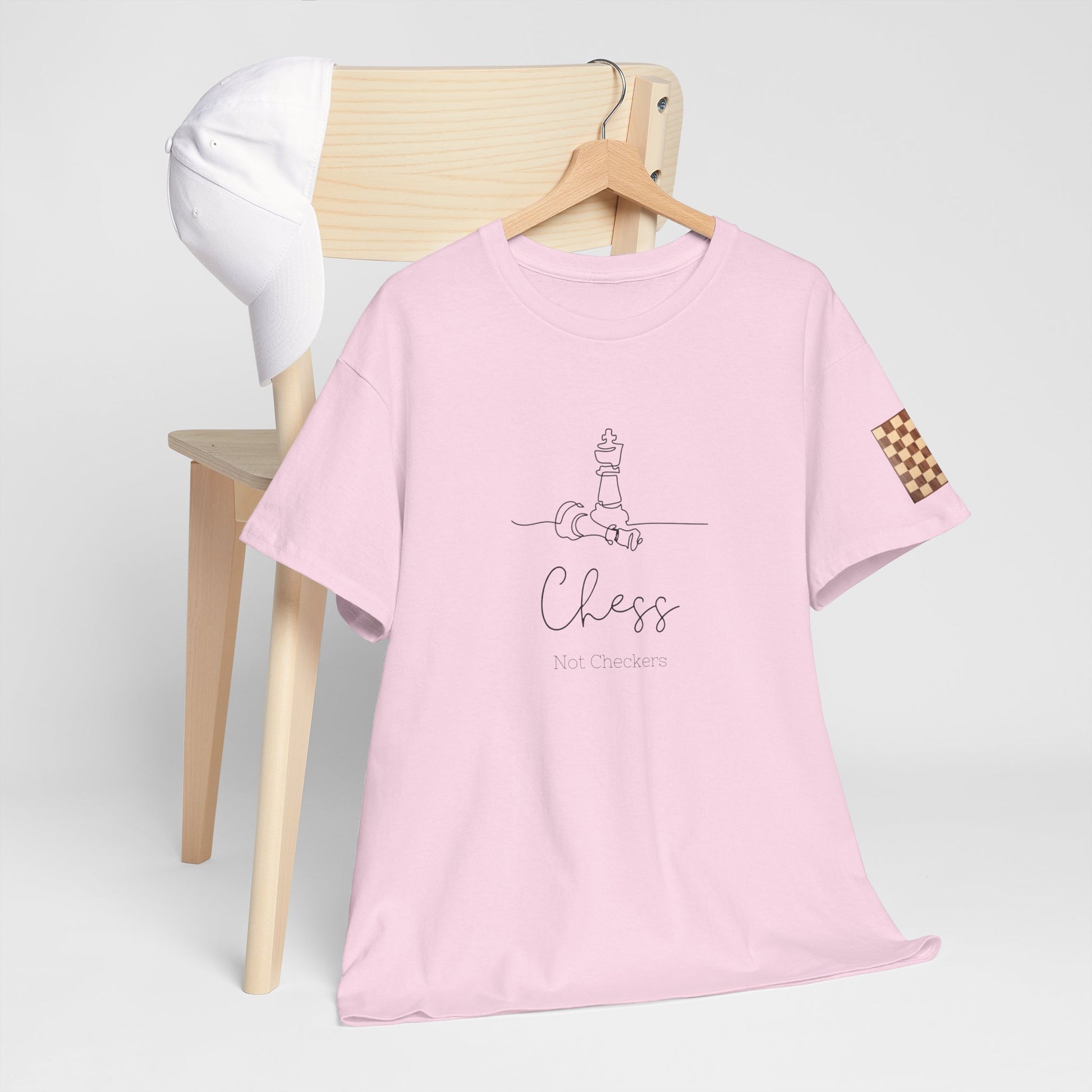 Pink t-shirt with 'Chess No Checkers' text on a wooden chair against a white background. Chess Not Checkers Print Design Chess Board Unisex Tee - Ethically Grown 100% Cotton - GILDAN