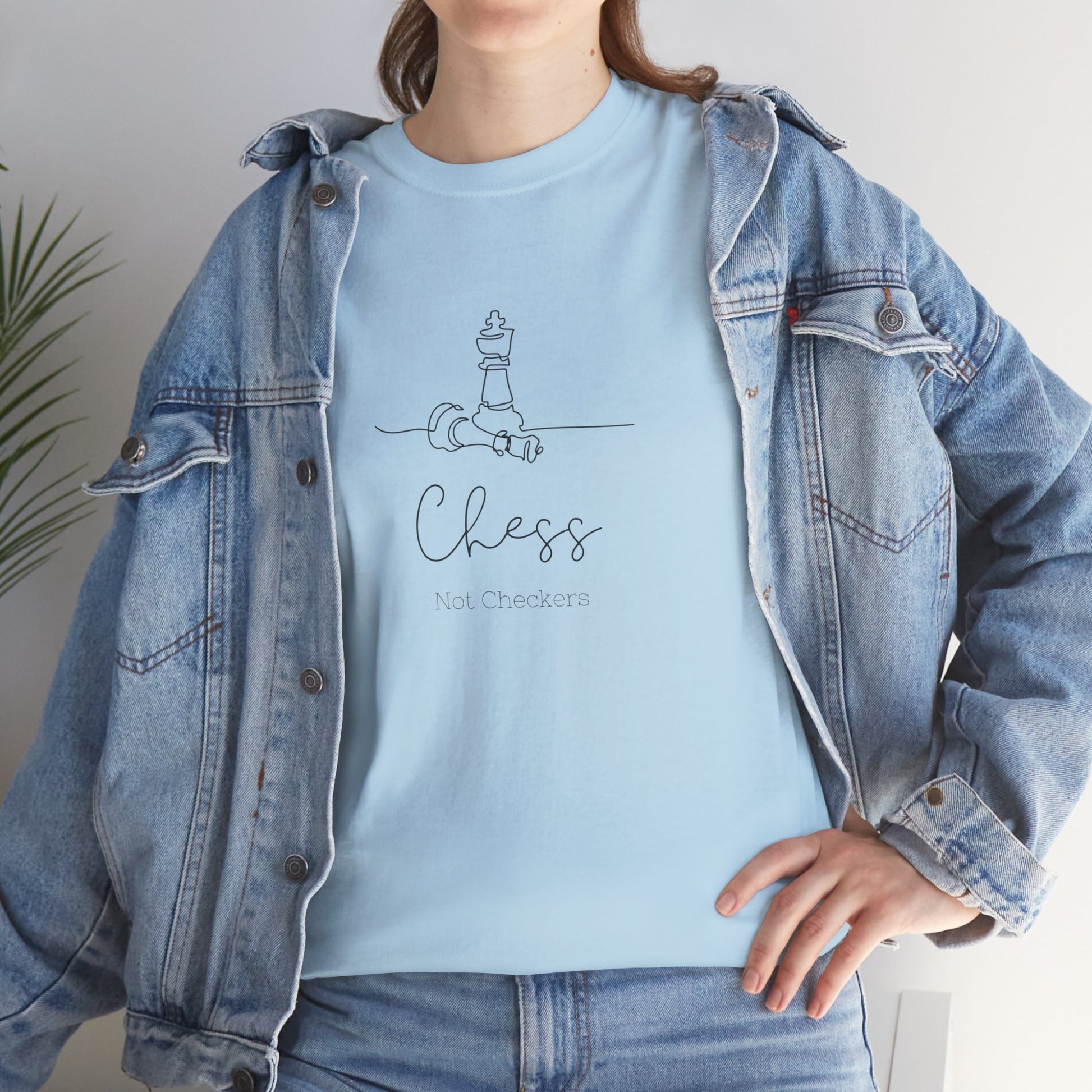 Person wearing a light blue t-shirt with a chess design and text, paired with a denim jacket. Chess Not Checkers Print Design Chess Board Unisex Tee - Ethically Grown 100% Cotton - GILDAN
