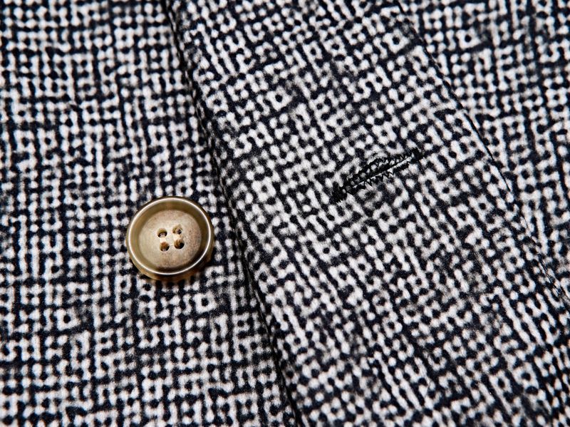 Close-up of a textured fabric with a button on a black and white patterned background Gray houndstooth patterned blazer worn by a person on a gray Make a statement with this sharp men's plaid blazer that's anything but boring. Designed with a contemporary slim fit and double-breasted front, this jacket brings effortless style to your everyday rotation. The premium polyester knit fabric feels as good as it looks—soft, breathable, and built to last. Rock it in timeless gray or rich brown