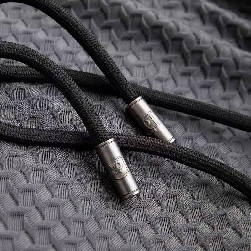 Close-up of black braided cable with metal connectors on a textured gray surface
