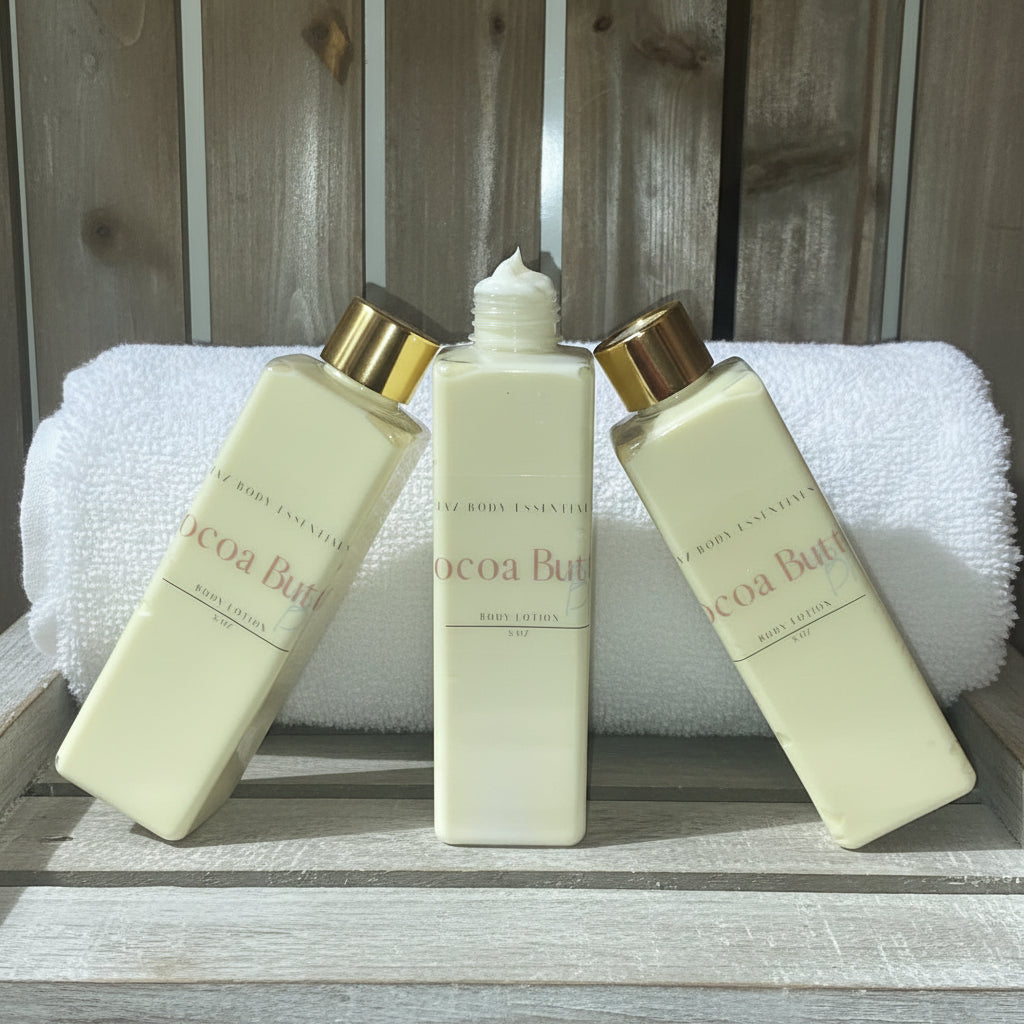 Three bottles of Cocoa Butter body lotion on a wooden surface with a towel in the background.