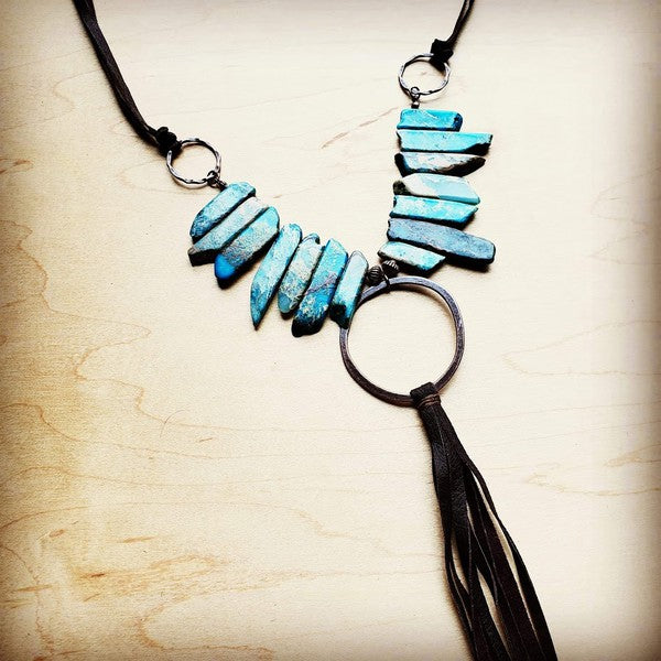 Copper Hoop on Imperial Jasper Slab Necklace Make a statement with a piece that refuses to blend in. A striking genuine Imperial Jasper stone slab takes center stage, framed by a gleaming copper hoop and crowned with a playful suede fringe tassel that swings with attitude. Adjustable from 24" to 36" with a self-tie closure, this necklace goes from laid-back boho to gallery-level chic in one move.