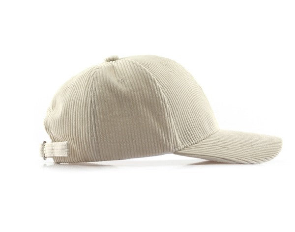 Side view of a beige ribbed corduroy boyfriend baseball cap with a curved brim and adjustable back strap on a white background.