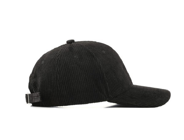 Side view of a black ribbed corduroy boyfriend baseball cap with a curved brim, adjustable back strap, and relaxed fit on a white background.