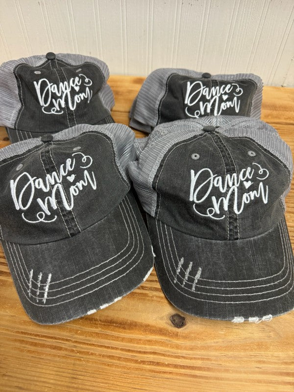 Four black and gray distressed hats with 'Dance Mom' text on a wooden surface. Dance Mom Embroidered Trucker Hat for Women - Adjustable Mesh Baseball Cap for Dance Competitions, Recitals & Everyday Wear