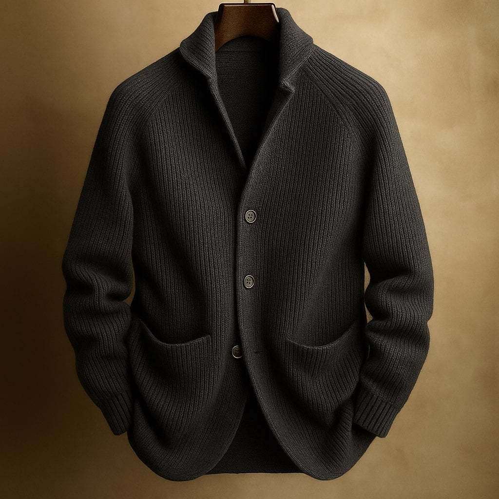 Dark gray knitted cardigan on a wooden hanger against a beige background