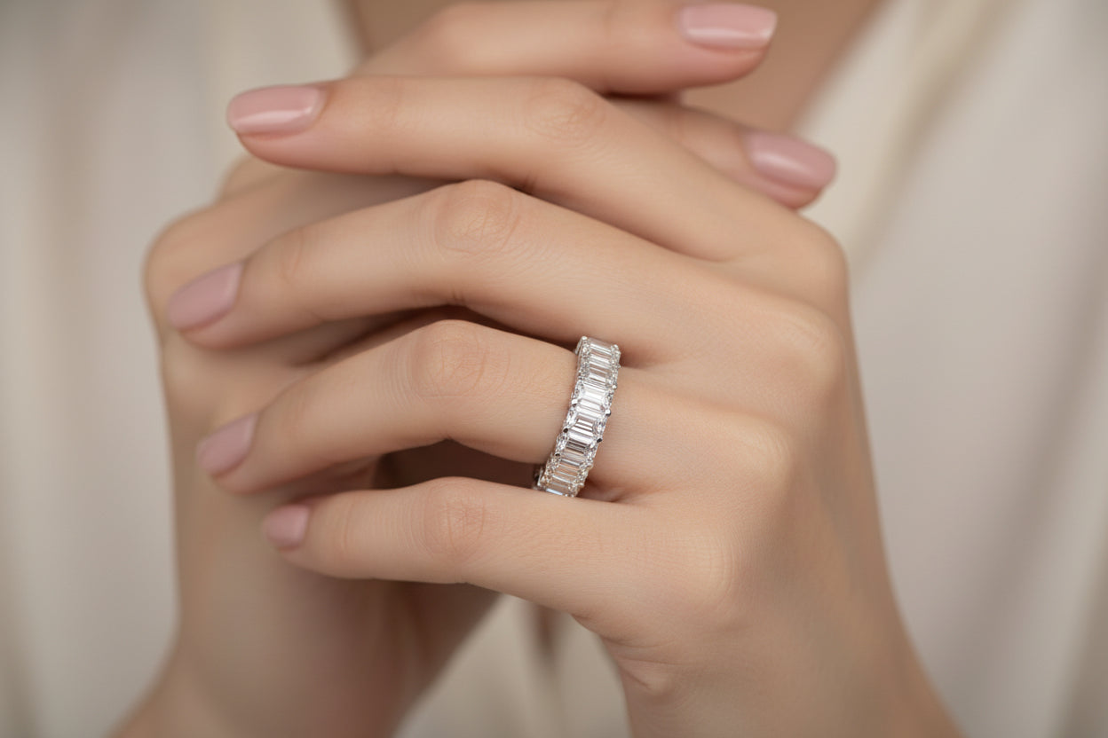 Diamond ring with emerald-cut stones on a white background Silver ring with clear gemstones on a white background Diamond ring with 'Ptac HOLYCOME' branding on a white background Moissanite brilliant cut ring 14K Gold Plated Brilliant Round Cut Moissanite Cluster Gemstone Ring