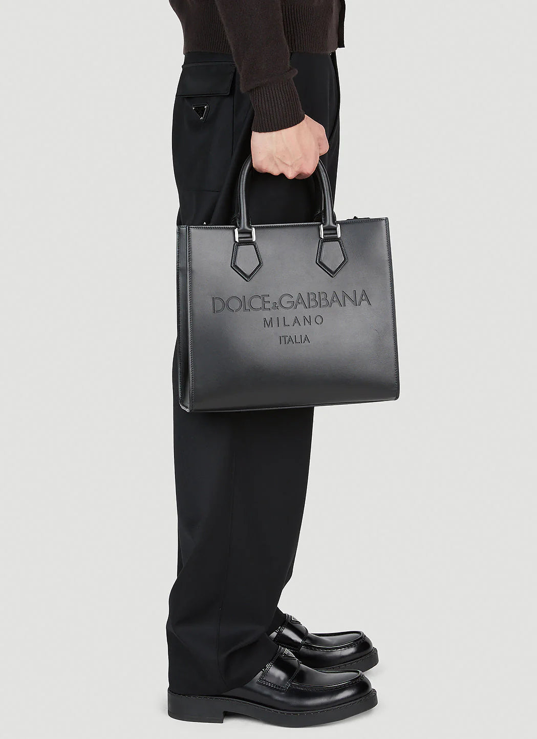 Person holding a Dolce & Gabbana handbag against a white background
