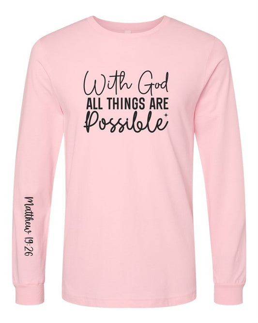 Light pink long-sleeve Christian T-shirt featuring the inspirational Bible verse "With God All Things Are Possible" on the front with Matthew 19:26 printed on the left sleeve.