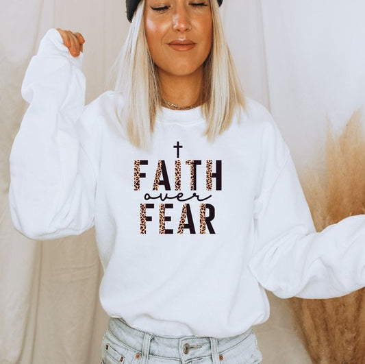 Person wearing a white sweatshirt with 'Faith over Fear' text
