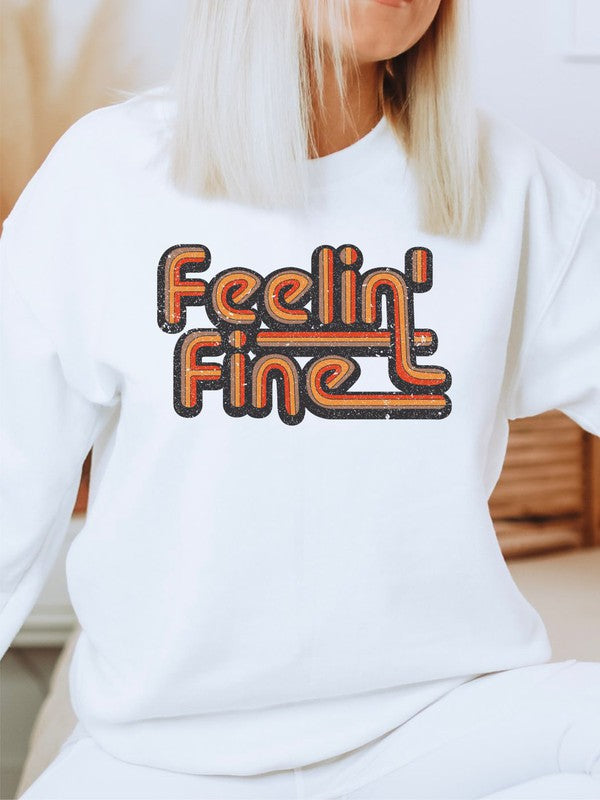 Person wearing a white sweatshirt with 'Feelin' Fine' text in orange and black.
