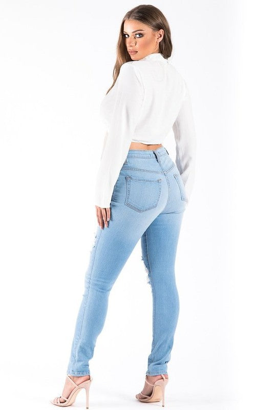 Full Length High Rise Skinny Jean features ripped detail, front button and zipper closure