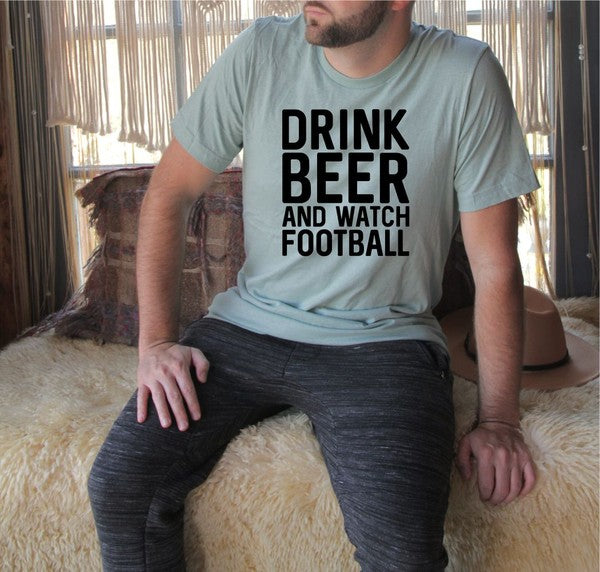 Man wearing a green graphic t-shirt featuring the bold slogan “Drink Beer and Watch Football” in large black lettering. This premium unisex ring-spun cotton tee combines casual comfort with sports fan style, making it perfect for football season, tailgates, game day parties, sports bars, weekend gatherings, and everyday wear. Styled with dark jeans beside a vintage motorcycle, this soft cotton graphic shirt is an ideal gift for football fans, beer enthusiasts, sports lovers, husbands, boyfriends, dads, and 