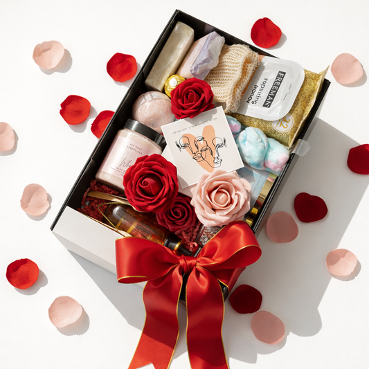 Gift box with beauty products, flowers, and a red ribbon on a white background with rose petals.