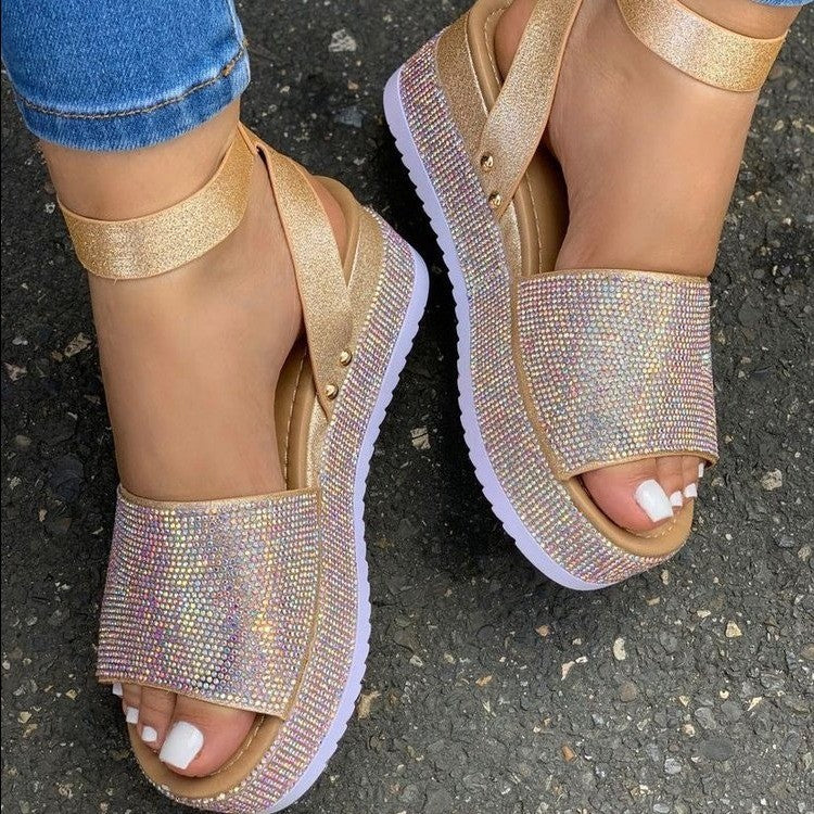 Gold glittery sandals worn on a dark surface