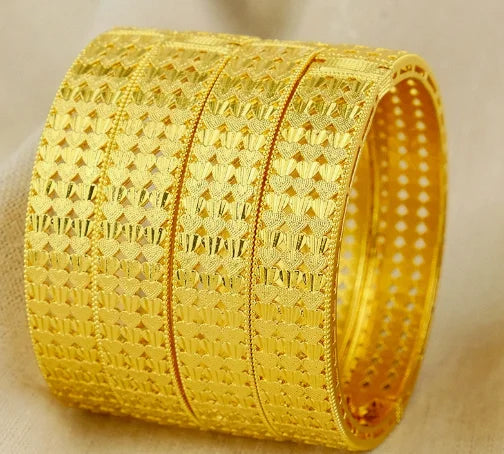 Gold bracelet with intricate patterns on a beige background