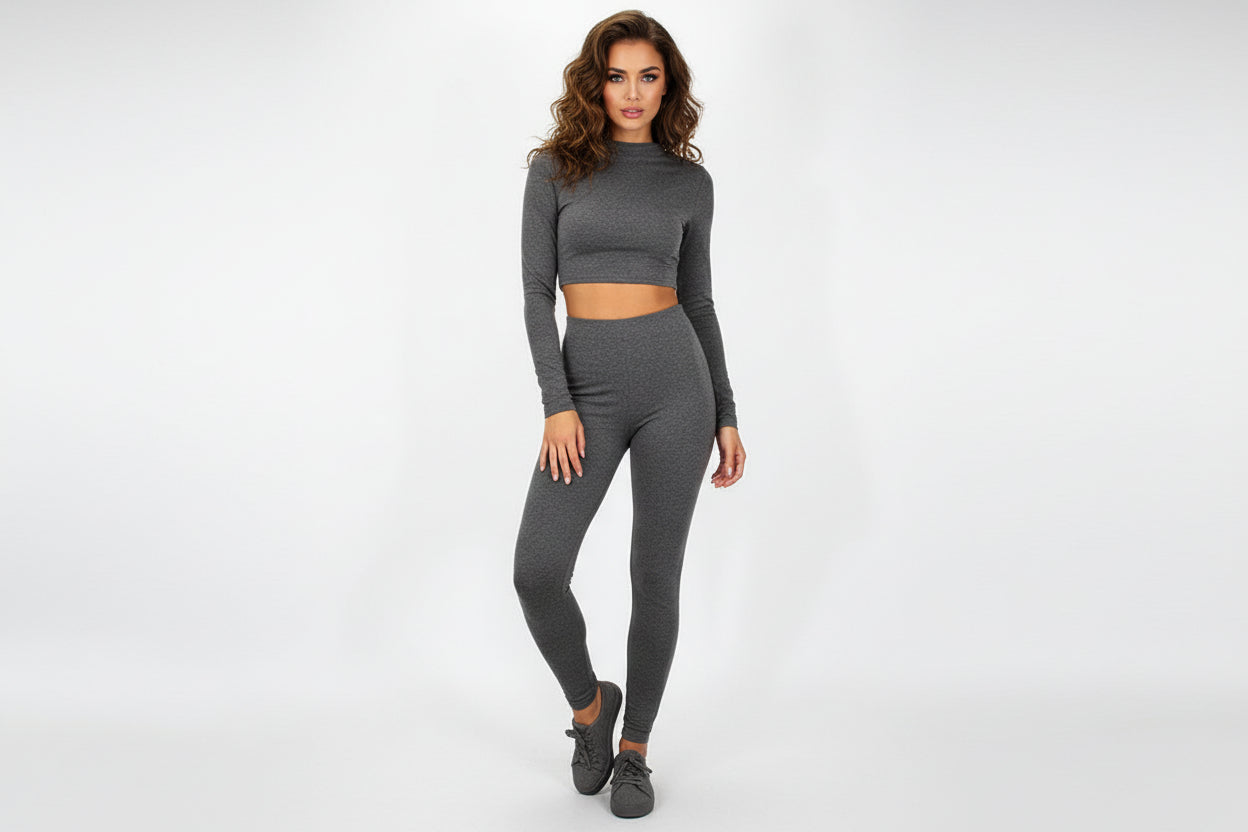 Gray long-sleeve crop top and gray leggings set on a white background