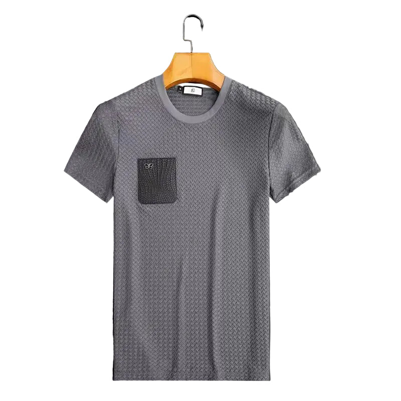 Gray textured t-shirt with a pocket on a hanger against a dark background