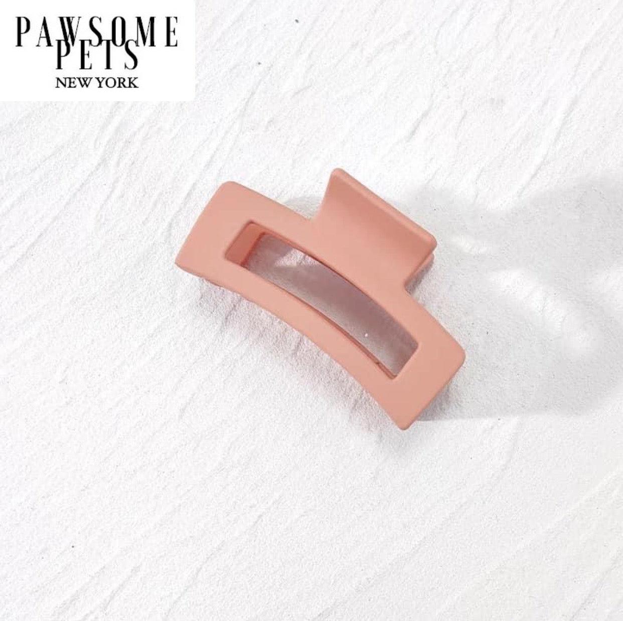 Pink hair claw clip accessory on a textured white background with 'PAW SOME PETS NEW YORK' branding.