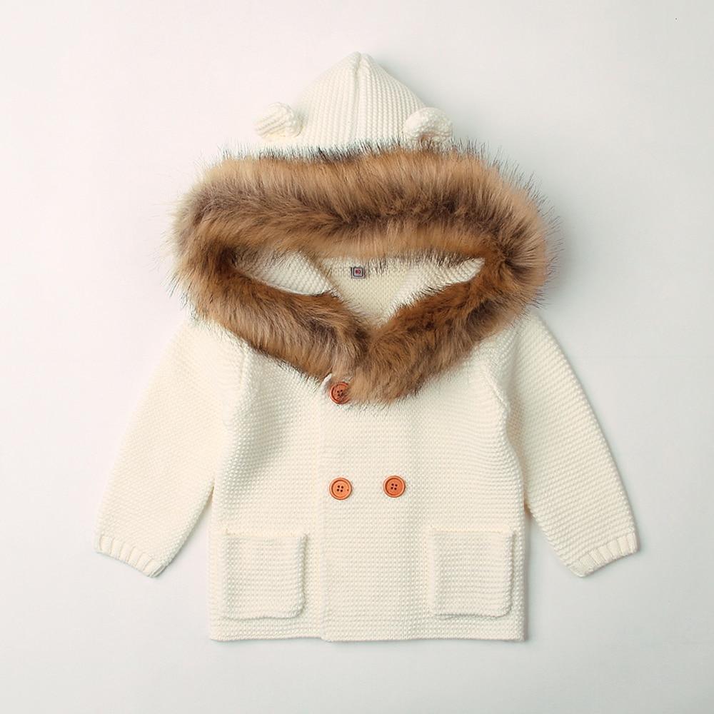 Children's cream-colored coat with brown fur hood on a light gray background