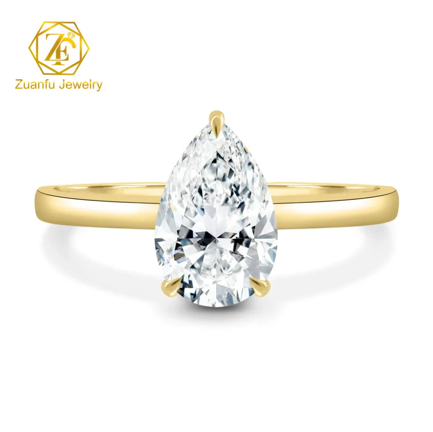 Gold ring with a pear-shaped diamond on a white background, featuring Zuanfu Jewelry logo.