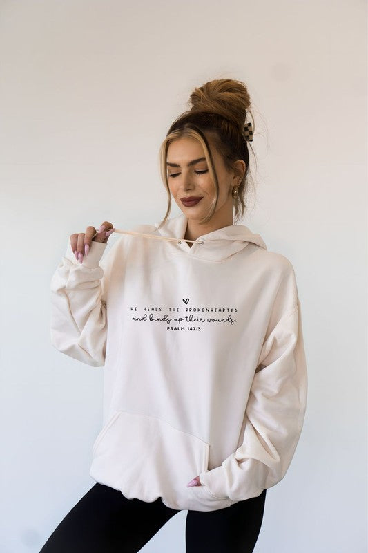 Woman wearing a white hoodie with text on a plain background