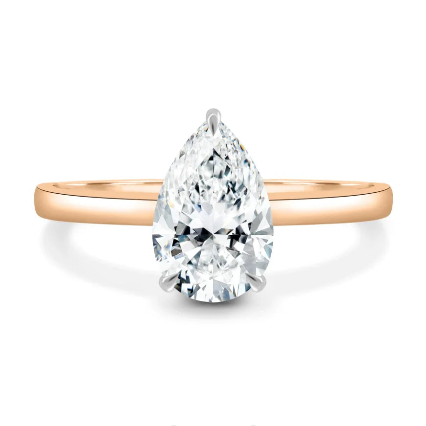 Rose gold ring with a pear-shaped diamond on a white background