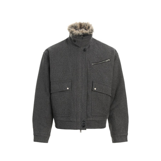 Dark gray men's high-neck winter jacket with a faux fur-lined stand collar, zip-front closure, flap chest pockets, and long sleeves on a white background. Warm insulated streetwear coat with a loose fit.