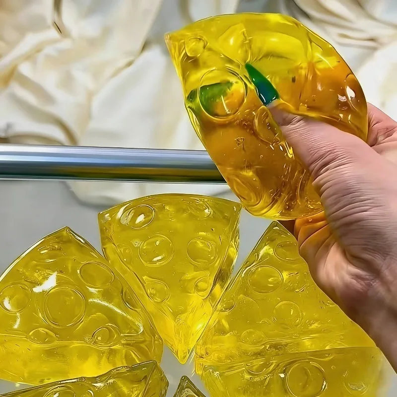 Honey Cheese Squishy Toy shaped like Swiss cheese made from soft yellow mochi gel, held in hand to demonstrate slow-rising stress relief, sensory fidget, anxiety relief, and tactile desk toy for kids and adults. Squishy Toy.