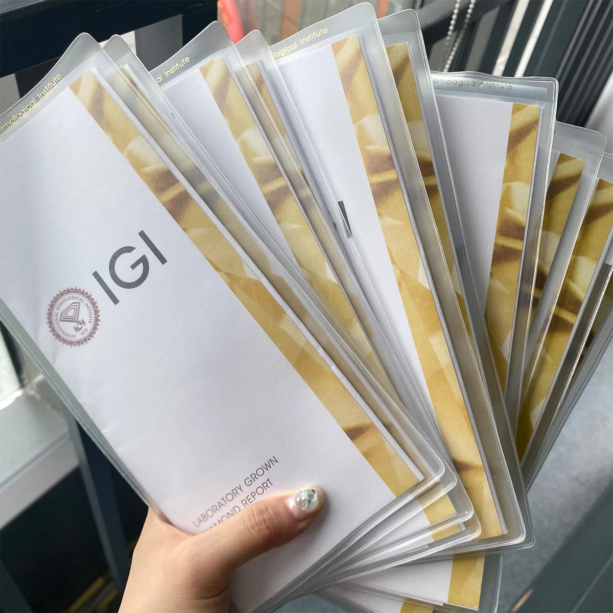 Hand holding a stack of IGI grow laboratory reports.