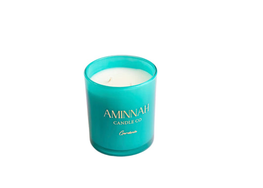 Turquoise candle with 'Aminnah Candle Co' branding on a white background
