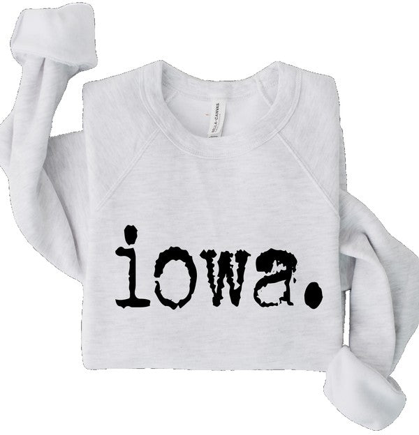 White Bella+Canvas crewneck sweatshirt featuring bold distressed black "Iowa." graphic, folded flat on a white background with sleeves wrapped around the garment.