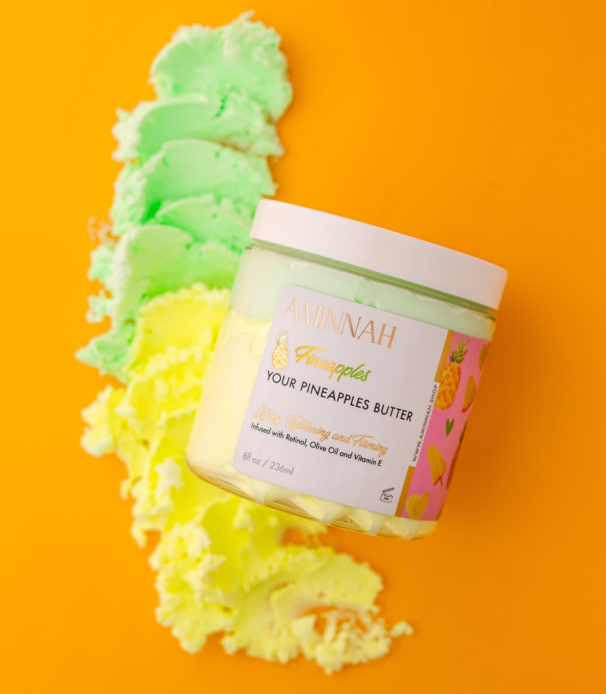 Jar of 'Your Pineapples Butter' on an orange background with green and yellow textured items.