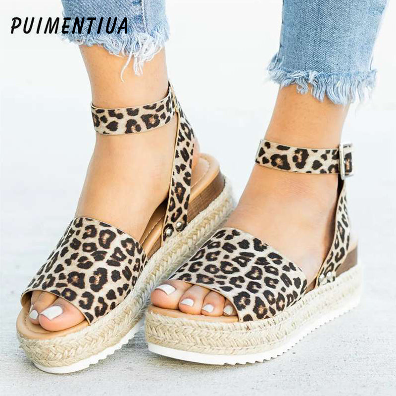 Leopard print sandals with espadrille sole worn by a person on a light background