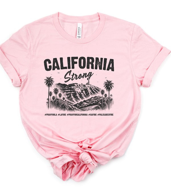 Pink unisex crew neck T-shirt featuring a black "California Strong" Hollywood graphic with palm trees and mountain landscape, symbolizing Los Angeles pride and resilience.