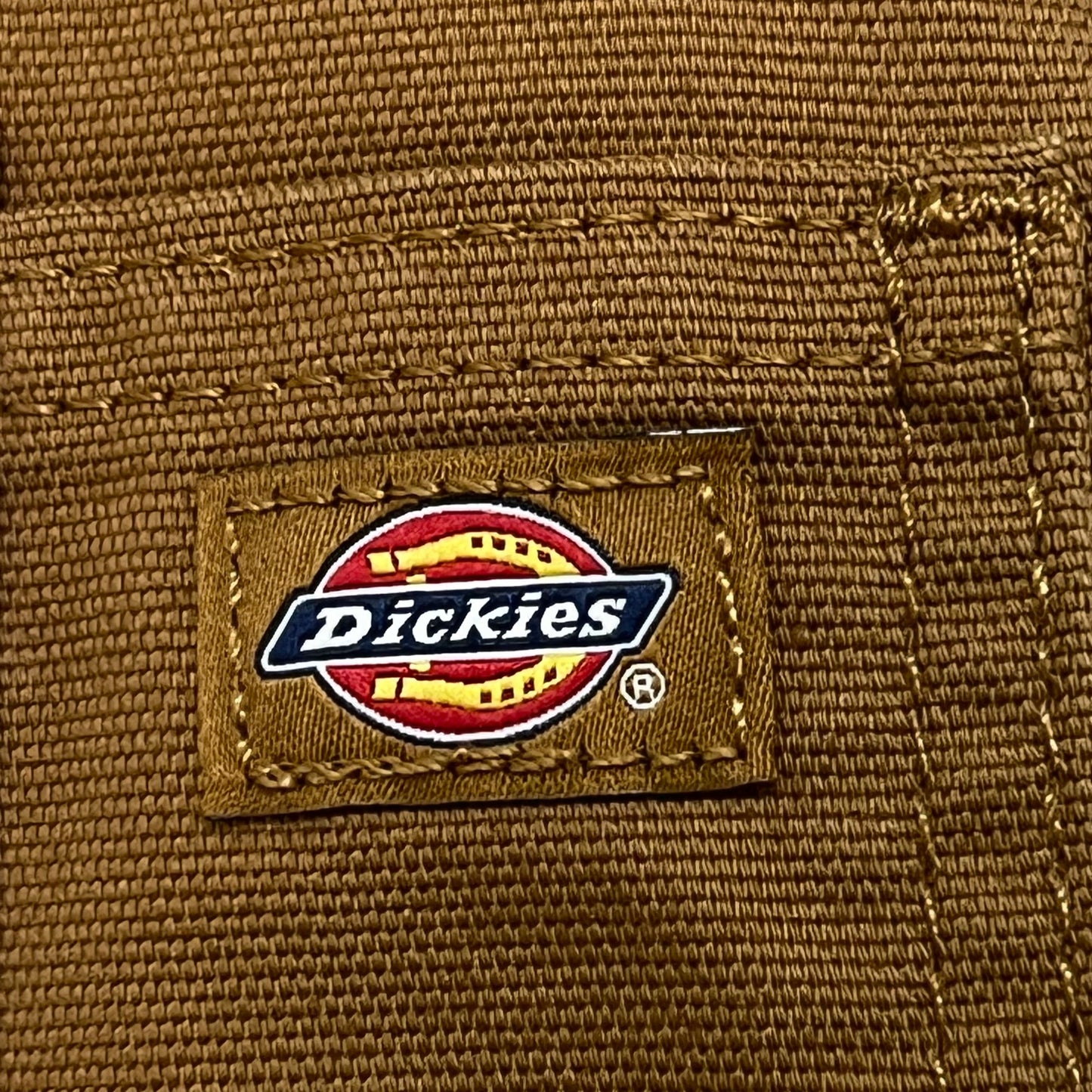 Dickies logo on a brown fabric background