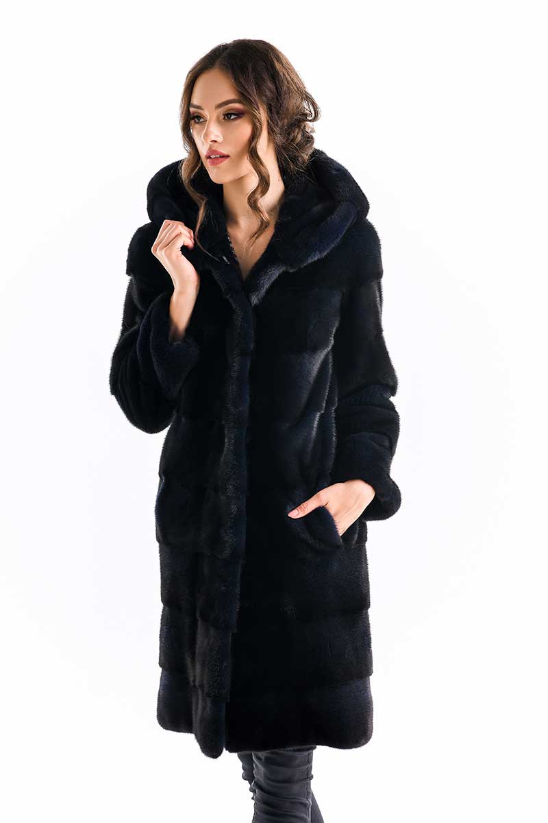 Woman wearing a black fur coat on a white background.