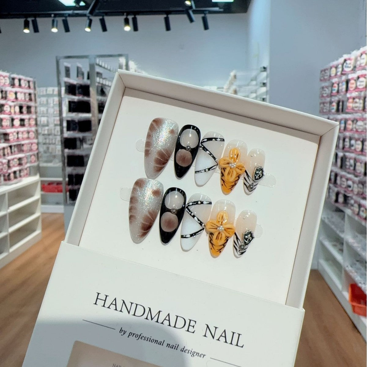 Display of handmade press-on nail art designs in a store setting.