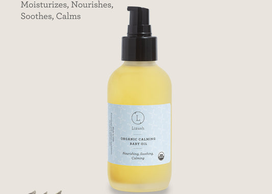 Yellow bottle of organic calming baby oil with a black pump on a light gray background. ORGANIC CALMING BABY OIL Nourishing, Soothing, Calming-0