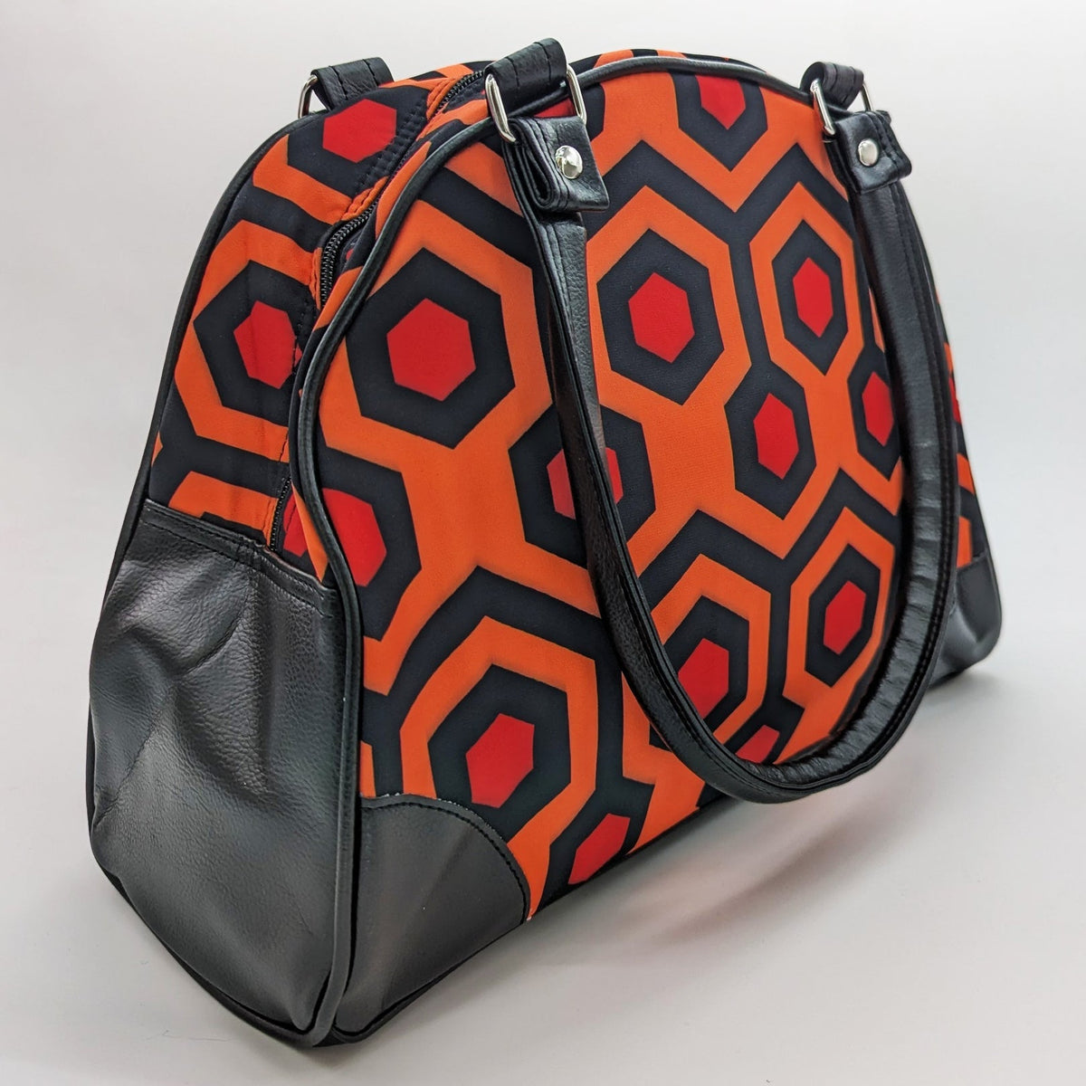 Bag with orange and red geometric pattern on a white background