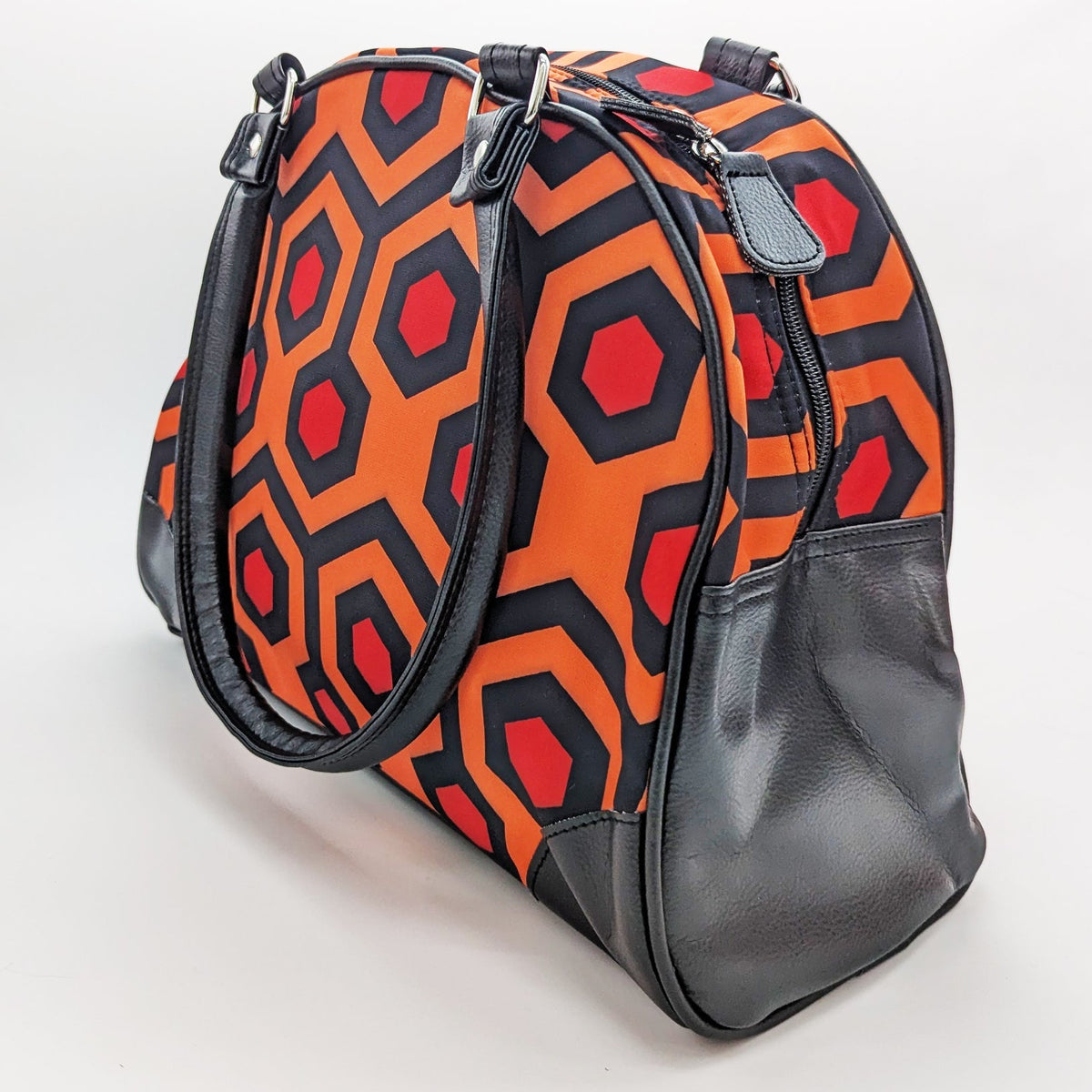 Patterned handbag with geometric design on a light gray background
