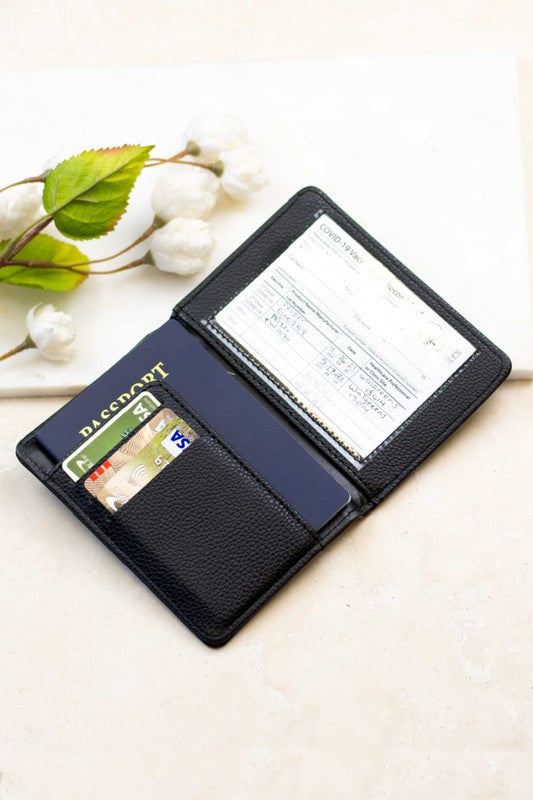 Black RFID passport travel wallet with card slots and transparent vaccine card holder, displayed open on a light surface with passport and credit cards, ideal for organizing travel documents and protecting personal information.