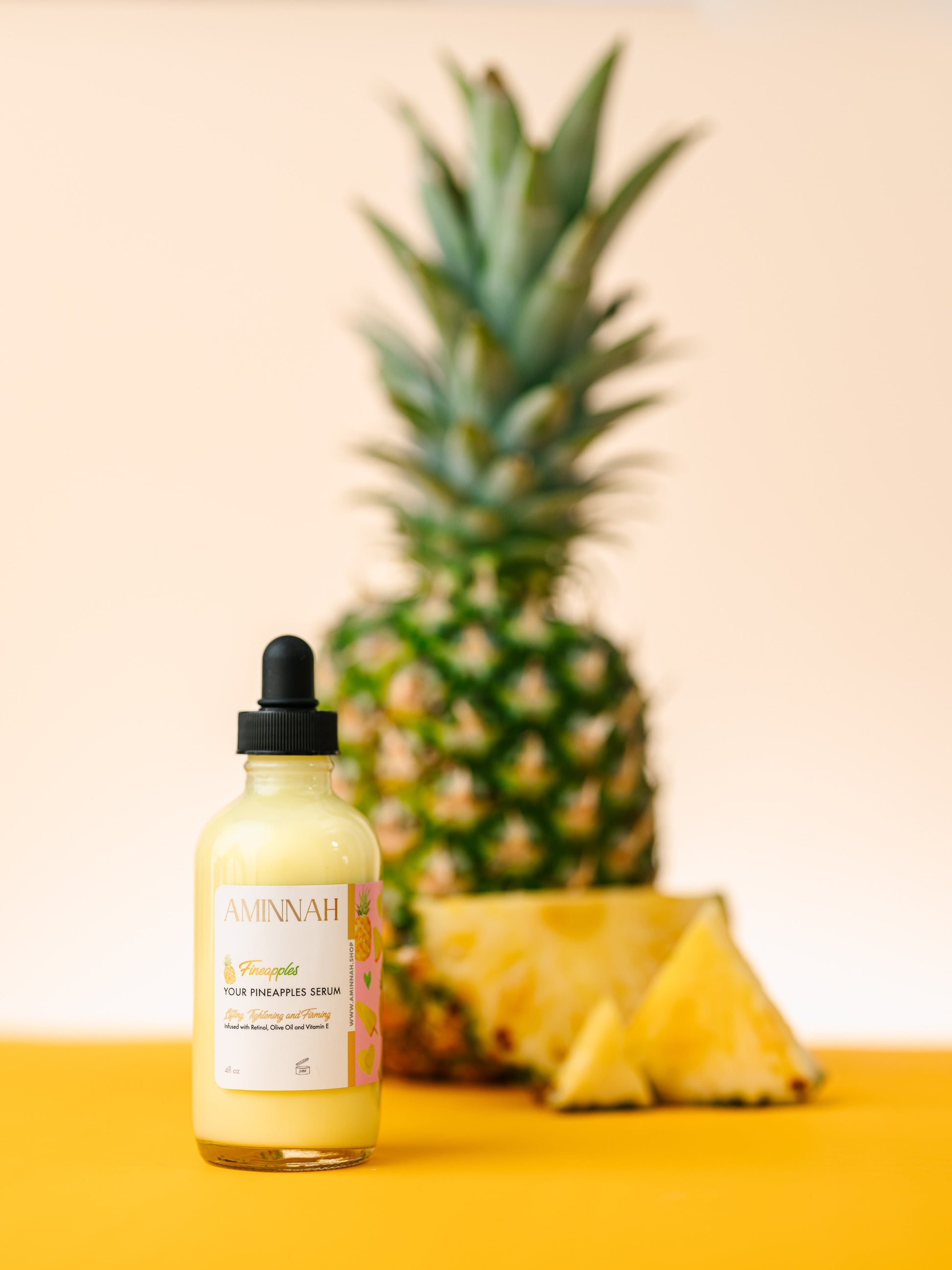 Vial of pineapple cream with a pineapple in the background on a yellow surface. Pineapple and skincare products on a yellow background. Bottle of pineapple serum with a dropper on a yellow background with pineapple slices. FIneapples anti-aging skin serum Vial of pineapple cream with a pineapple