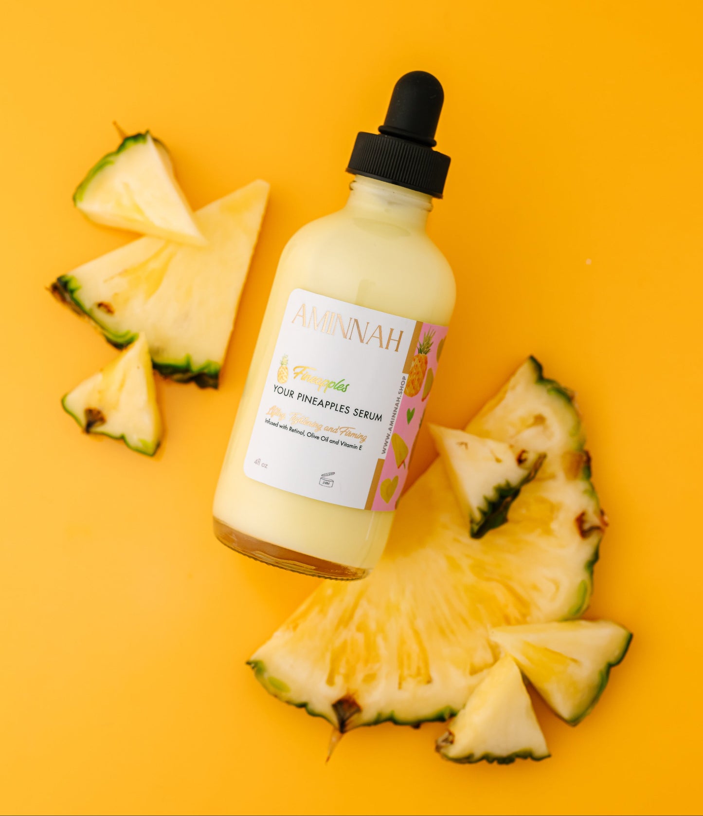Bottle of pineapple serum with slices on a yellow background. Pineapple and skincare products on a yellow background. Bottle of pineapple serum with a dropper on a yellow background with pineapple slices. FIneapples anti-aging skin serum