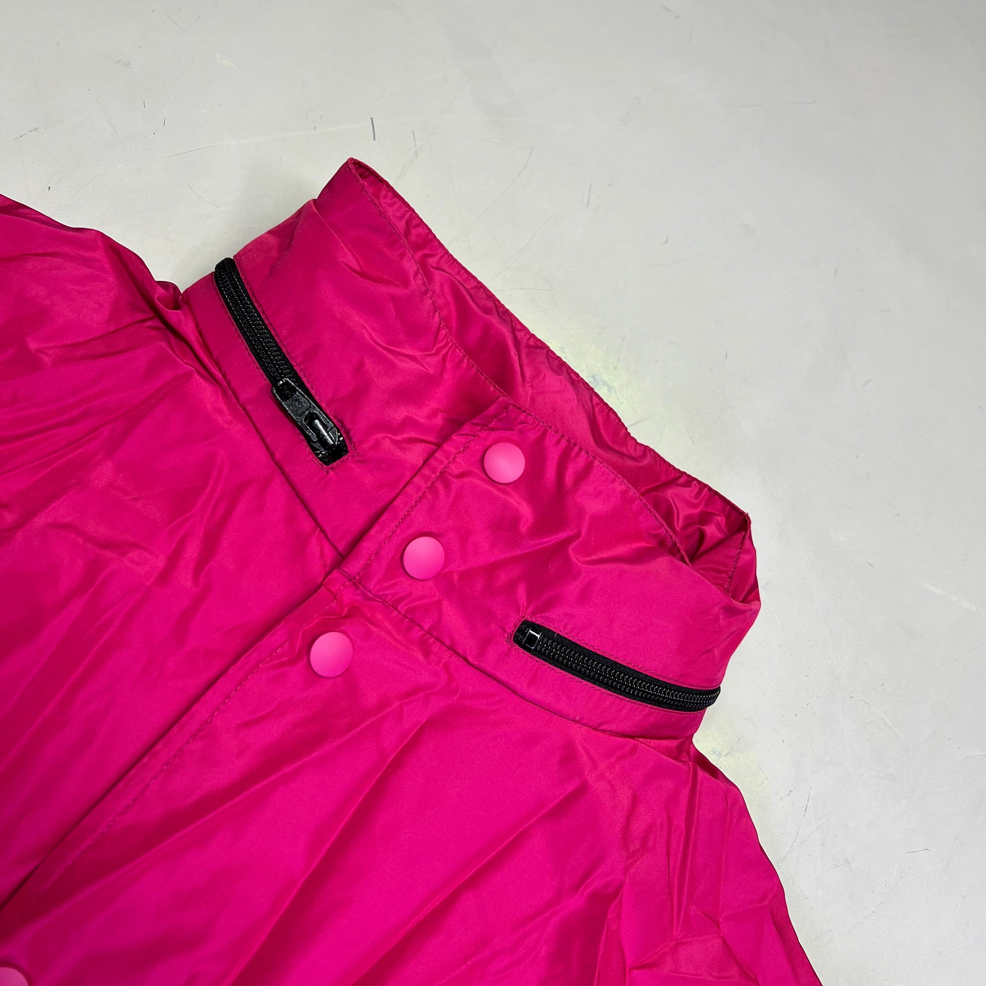 Pink jacket with buttons and zippers on a white background