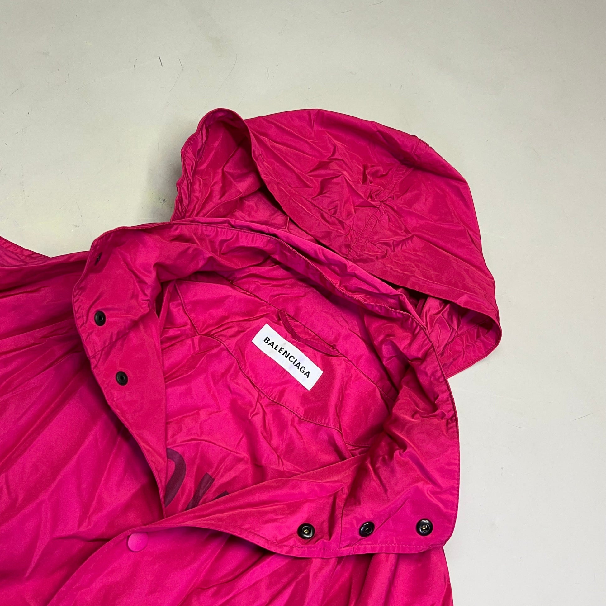 Pink jacket with a visible brand label on a light gray background
